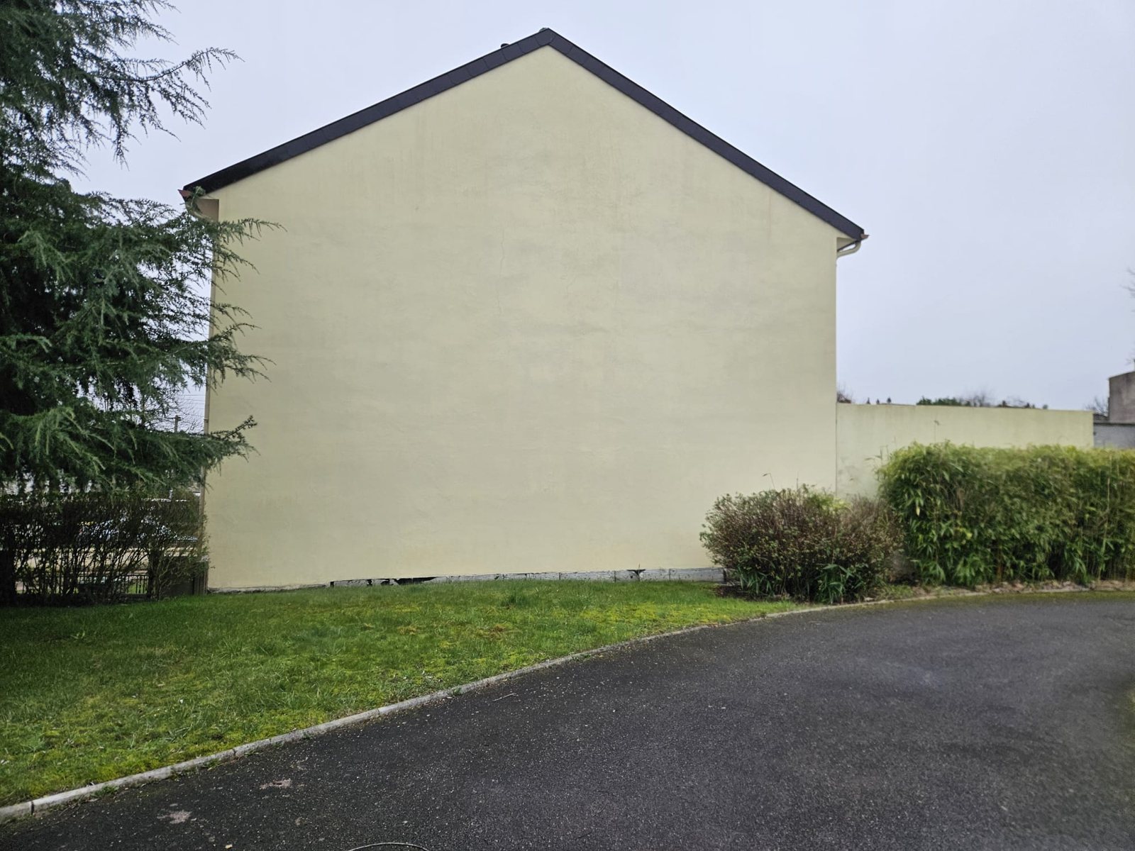 Pignon beige nettoyé, au bout d'une allée.