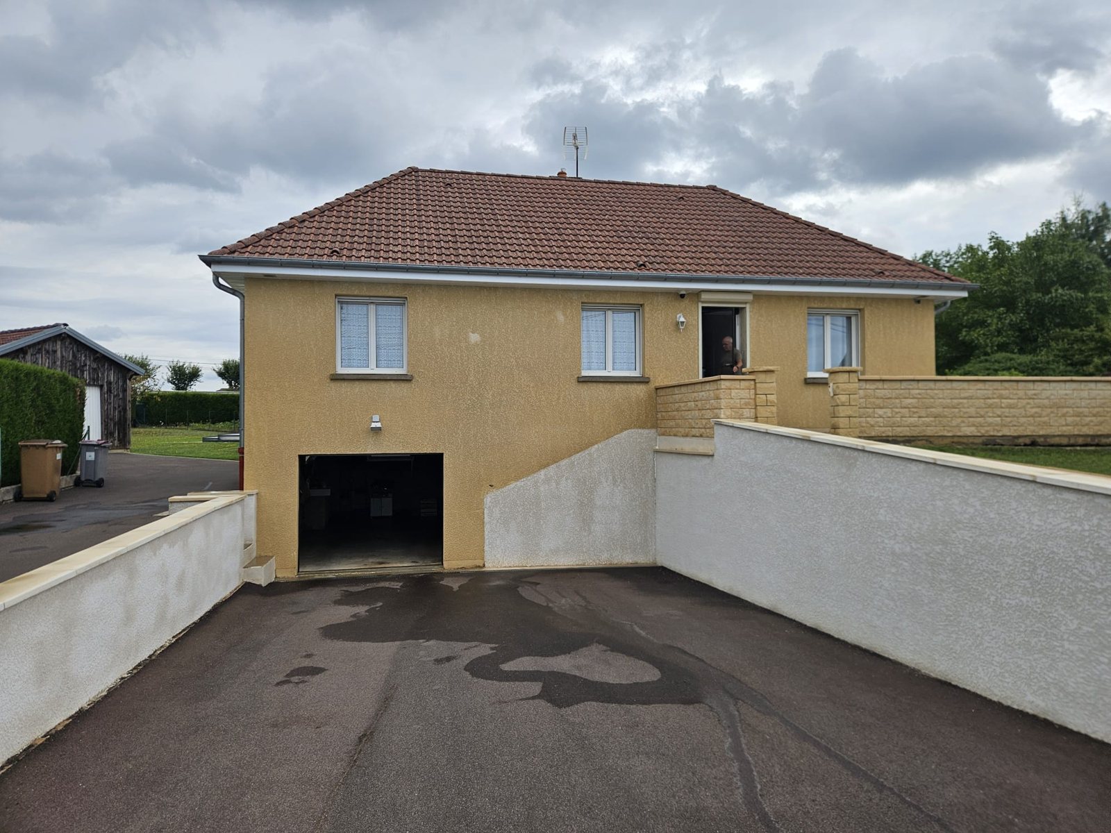Avant : maison sur garage, façade jaunie.