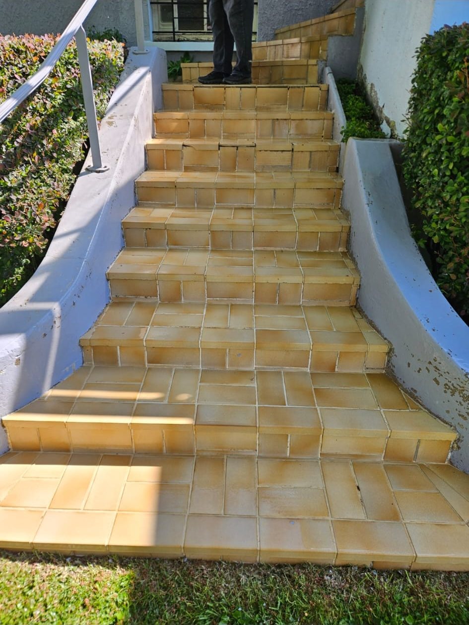 Après : le même escalier, carrelage jaune et orangé propre.