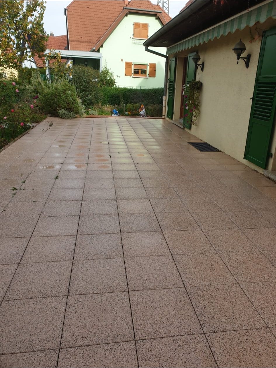 Terrasse carrelée propre le long de la maison.