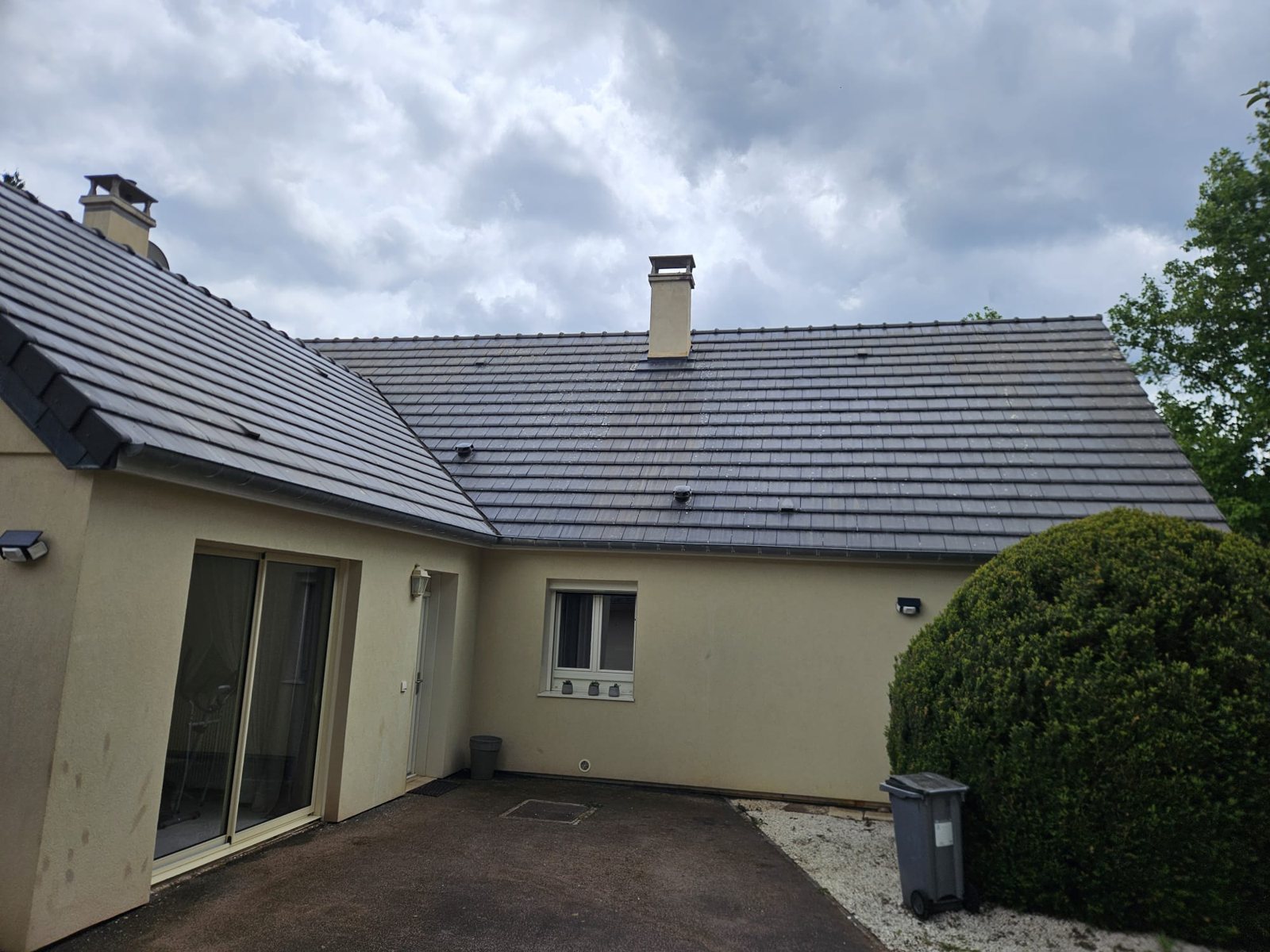 Toiture grise d'une maison en L, propre.